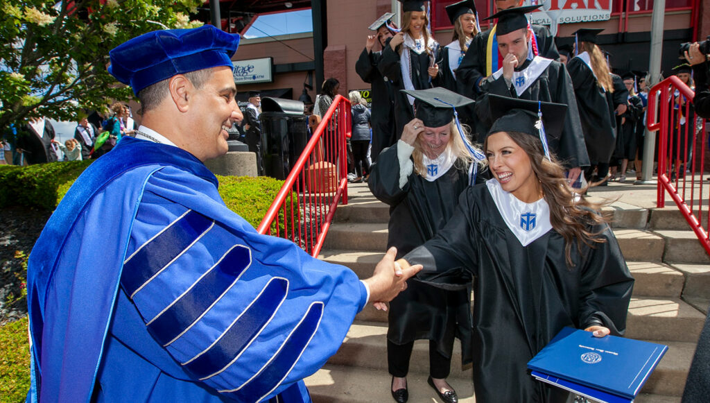 President Joe Chillo congratulates the newest graduates of Thomas More University outside of Thomas More Stadium.