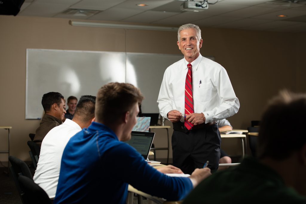 Male Professor smiling at his students