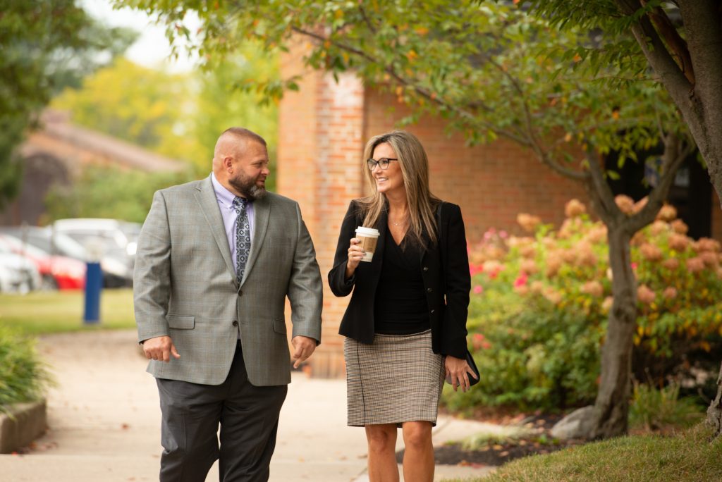 man and woman walking together and talking outside