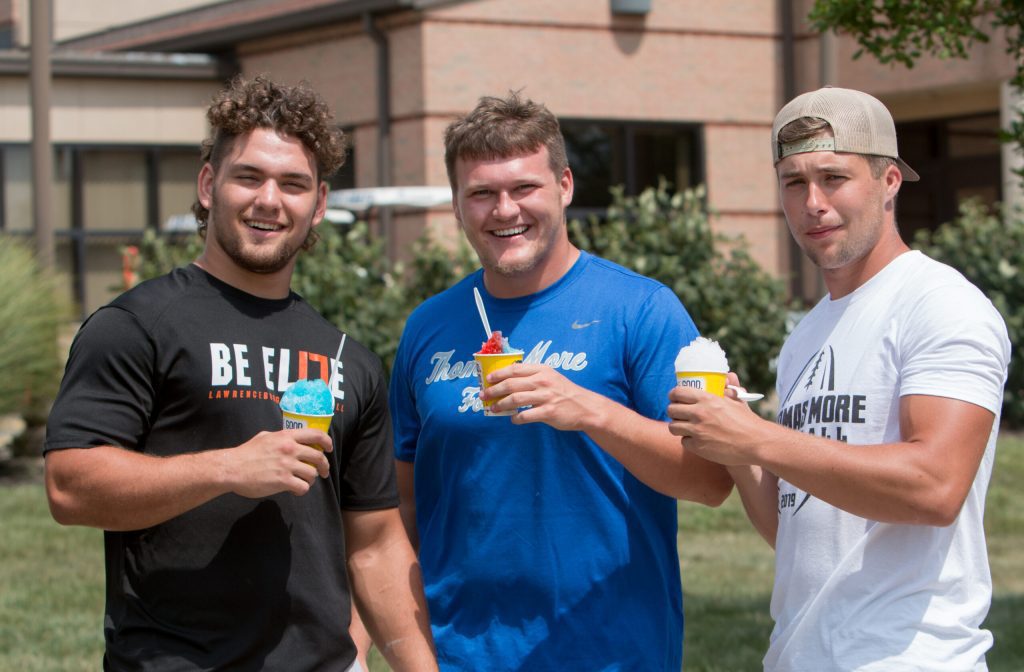 3 men holding shaved ice