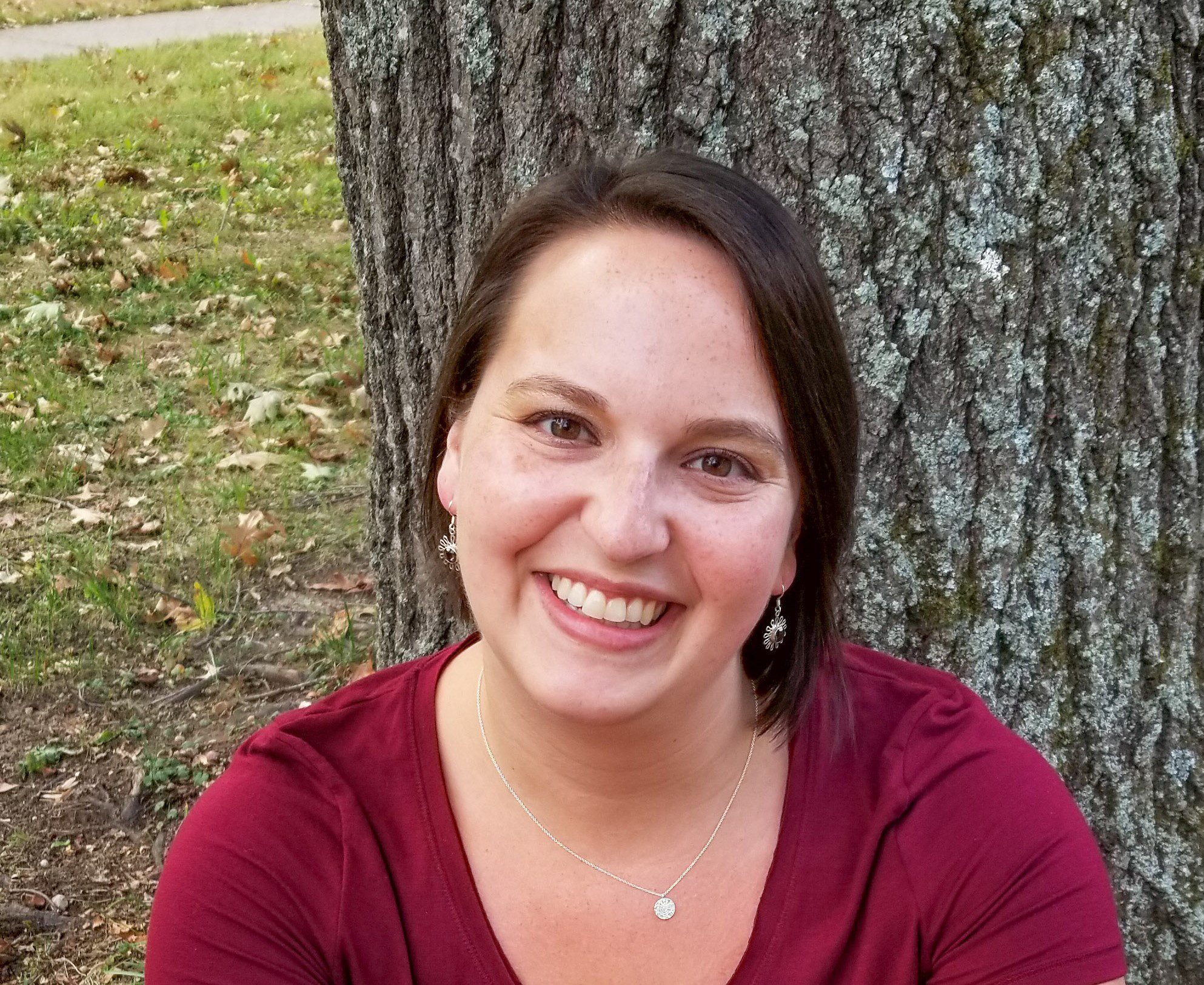 Woman in red sweater smiling outside