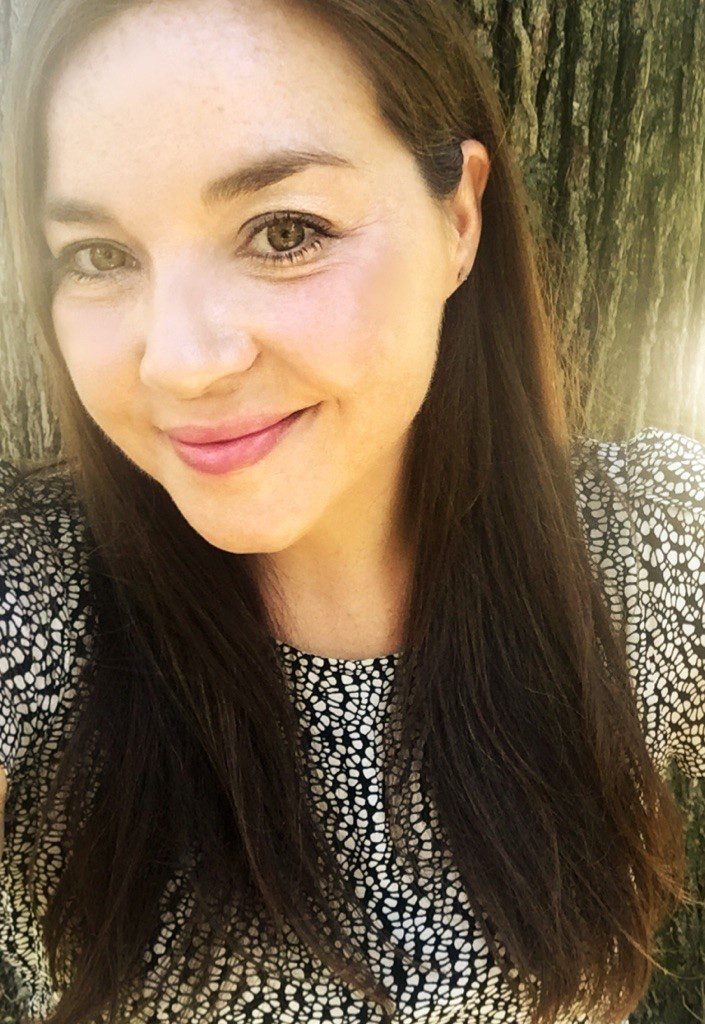 Woman smiling in front of tree